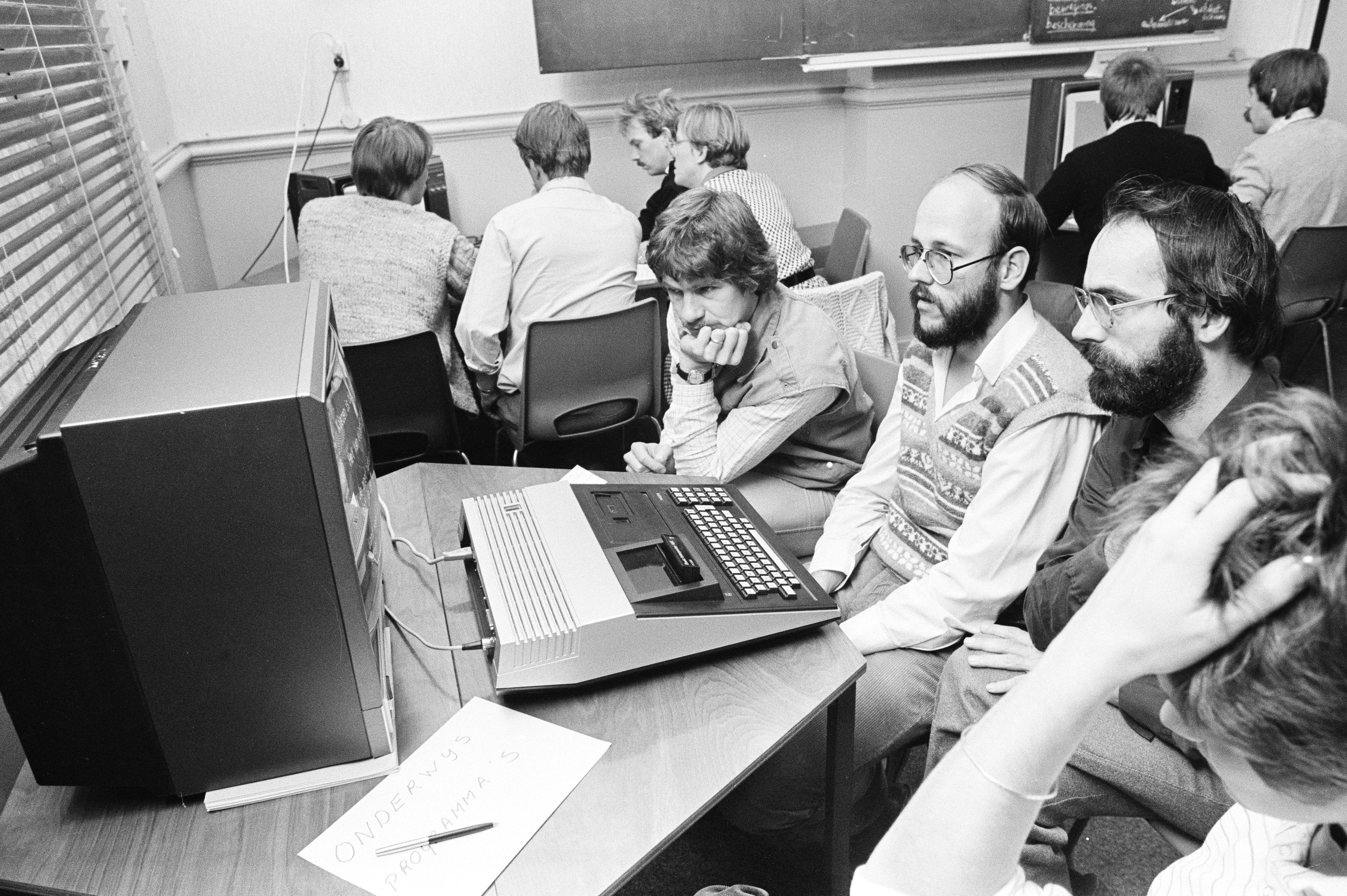 Vier mannen kijken vragend naar een computer